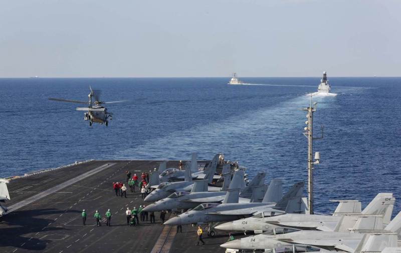 The aircraft carrier USS Abraham Lincoln transits the Strait of Hormuz as an MH-60S Sea Hawk helicopter lifts off from the flight deck on Nov. 19, 2019.