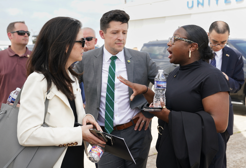 Rebecca Lissner (left), the deputy national security advisor to U.S. Vice President Kamala Harris, and policy advisor Ike Irby (center) speak with communications director Kirsten Allen before departing George Bush Intercontinental Airport in Houston, Texas, on Aug. 1.