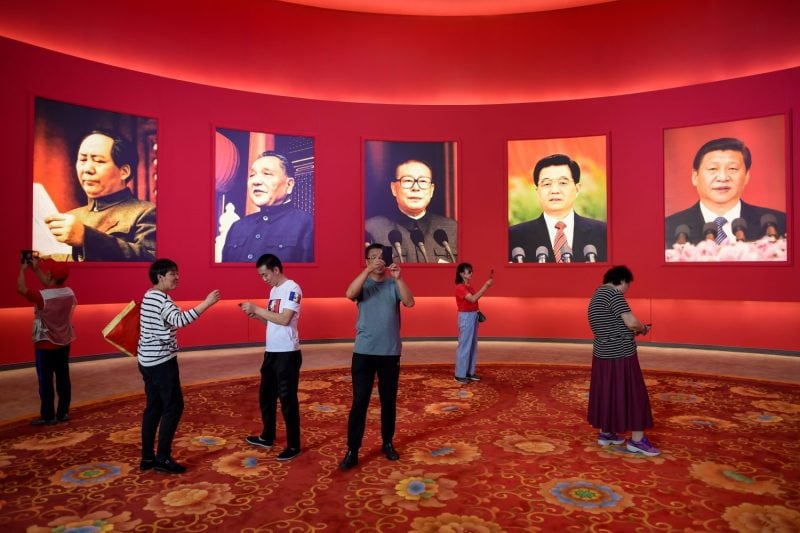 Visitors take pictures in front of portraits of Chinese leaders at an exhibition marking the 70th anniversary of the founding of the People’s Republic of China, in Beijing on Sept. 26, 2019.