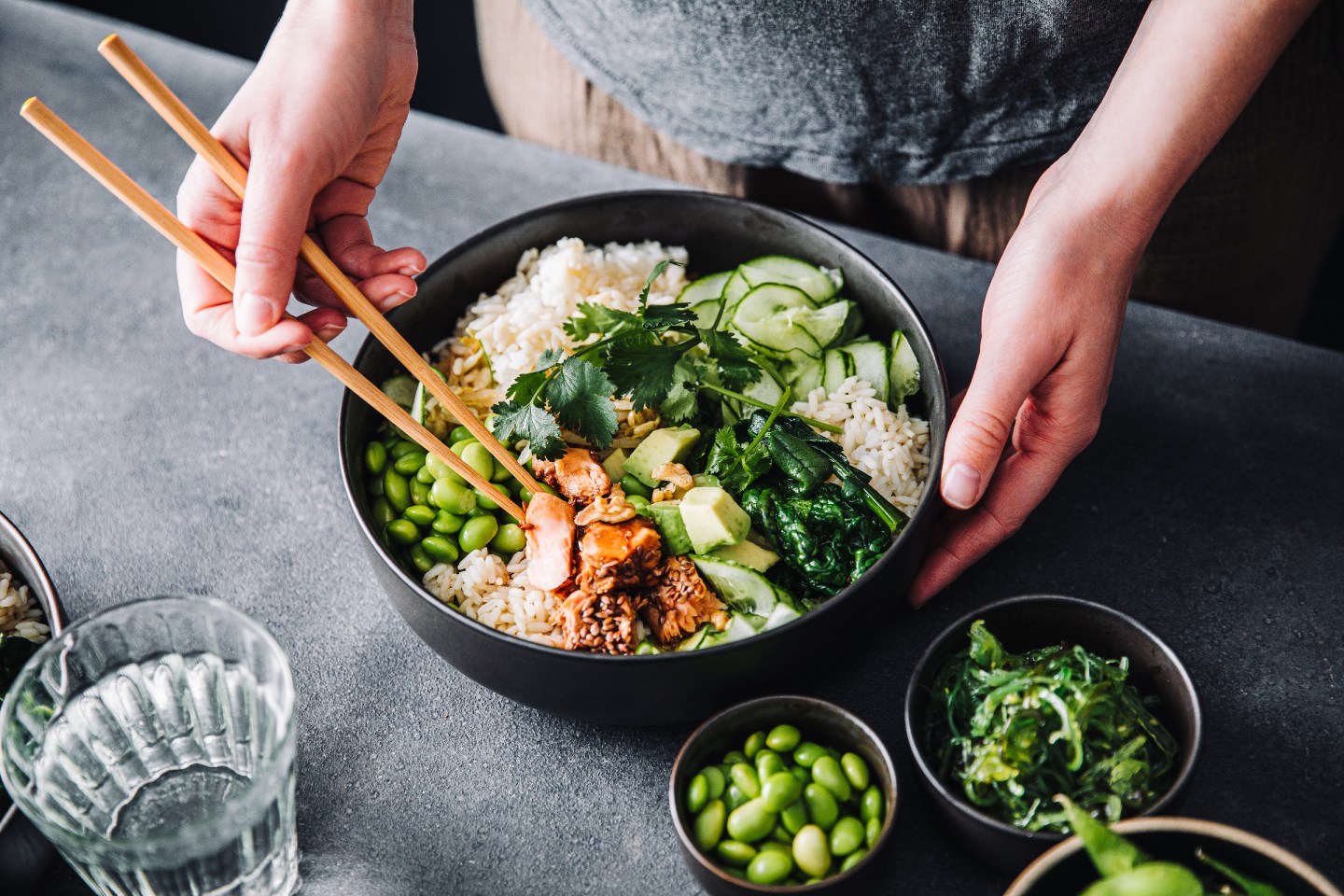 Close-up of a woman eating poke salad with chopsticks