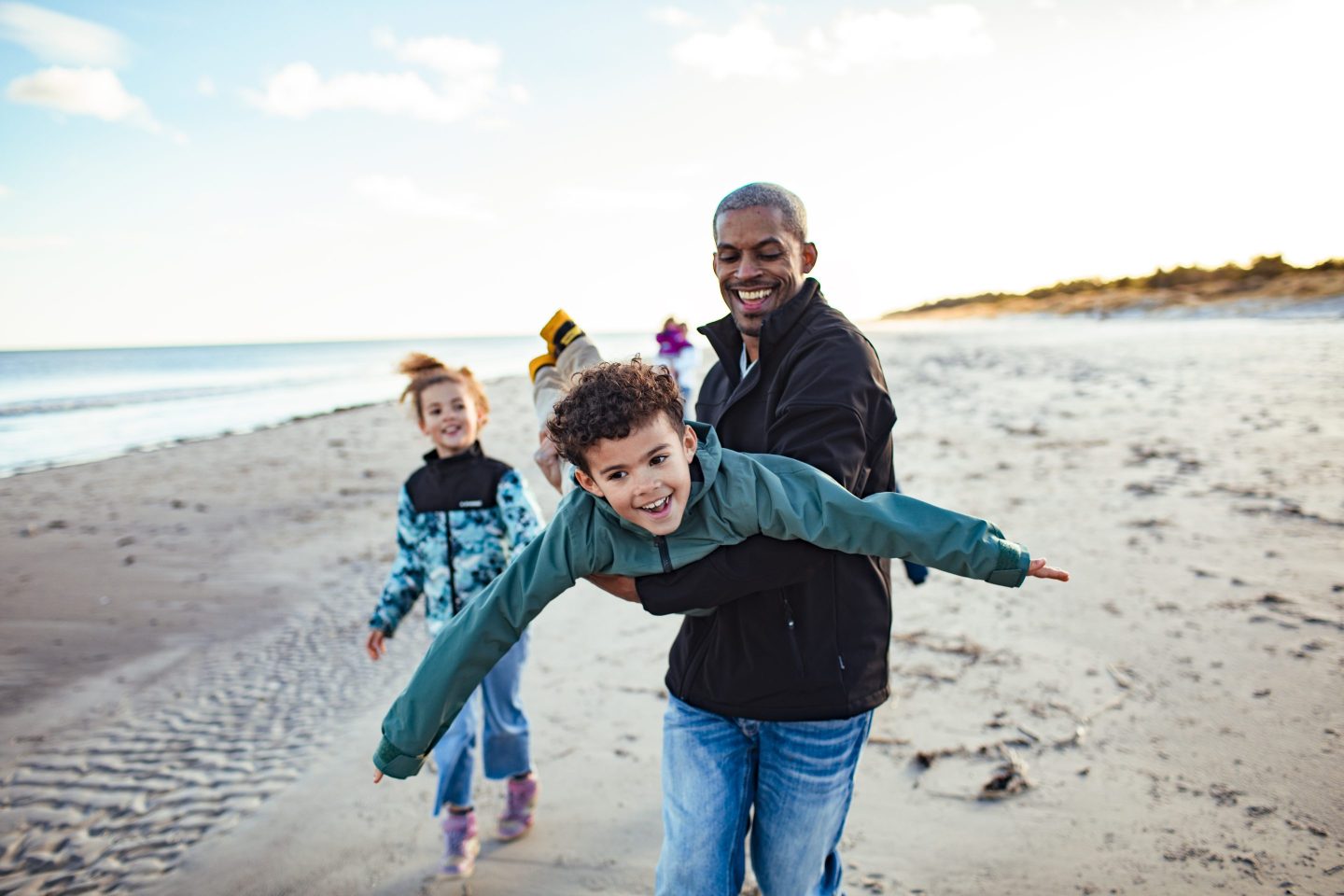 Close up of a young family enjoying time together on the beach during the winter