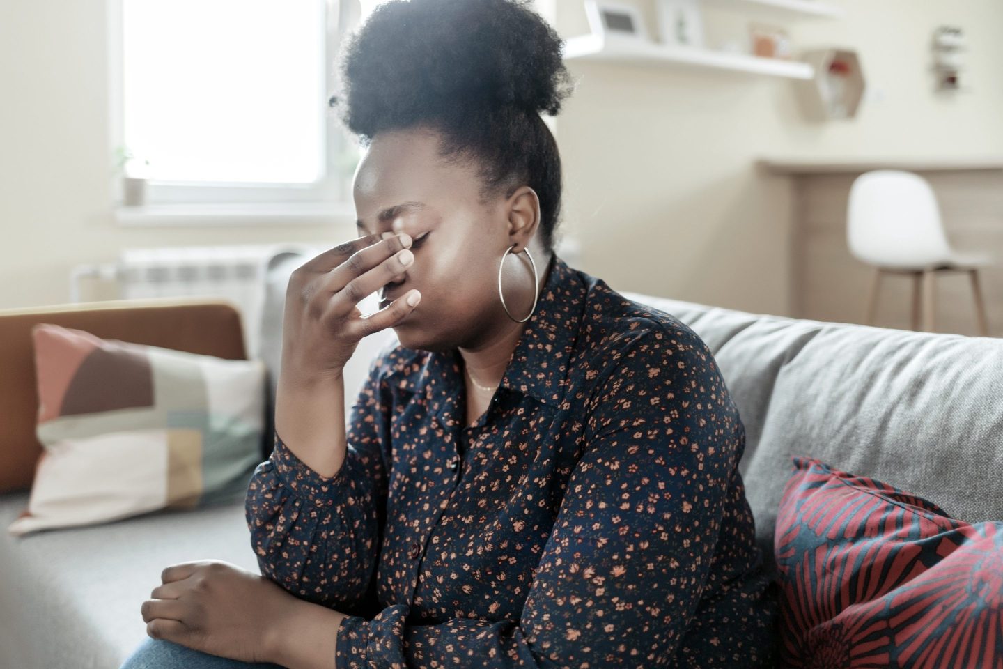 Woman holds her head in pain