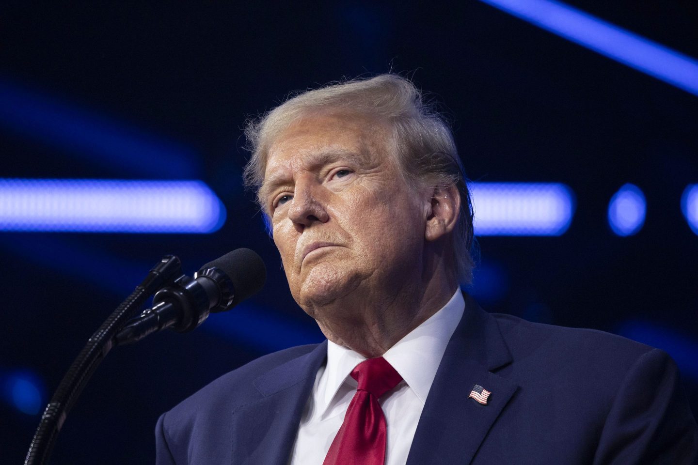 Donald Trump stands next to a microphone at a conference.