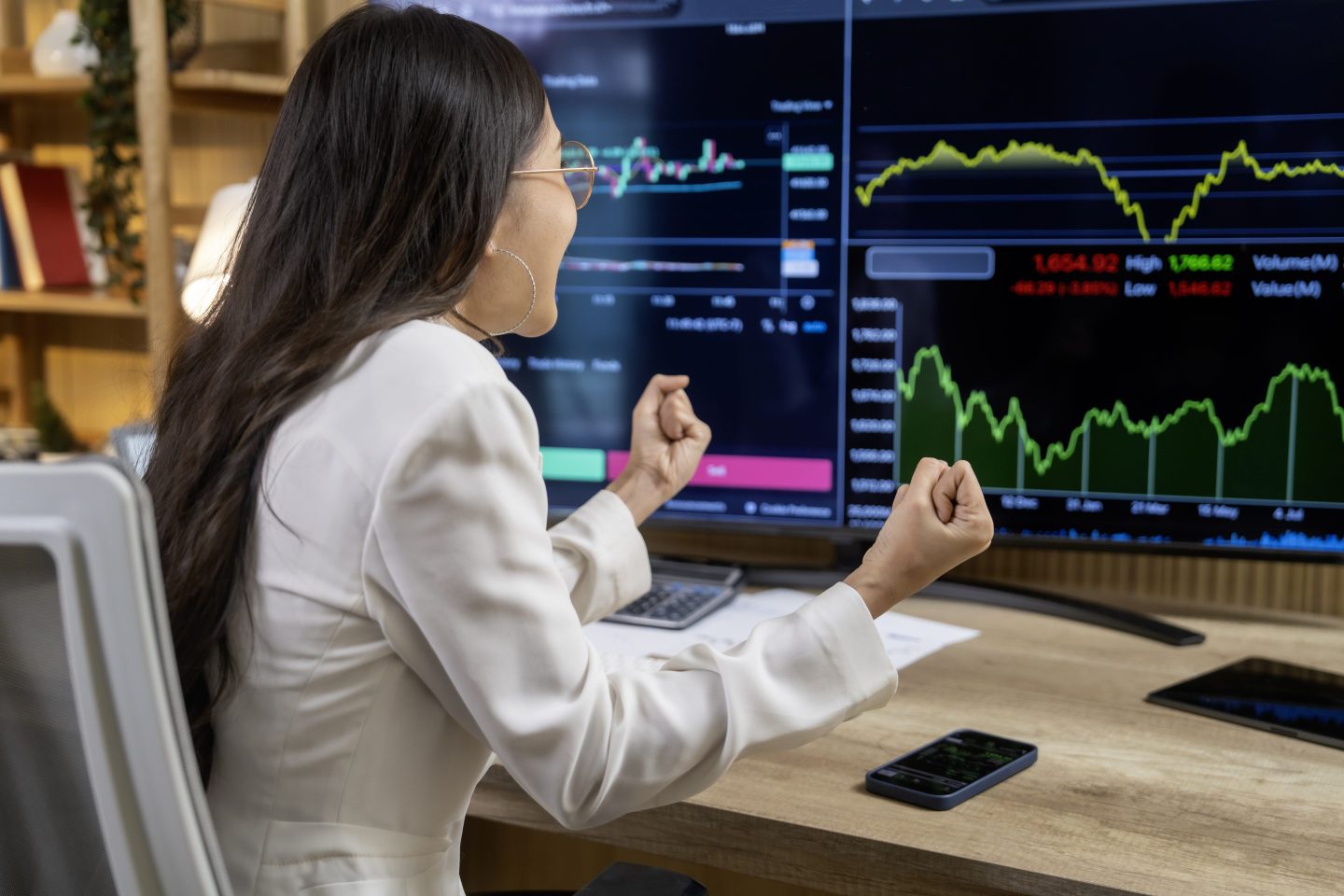 woman cheers at stock screen