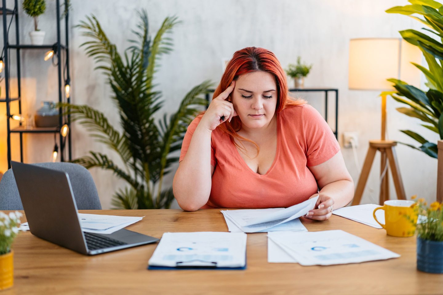 Young Woman sitting with a stack of papers at her desk