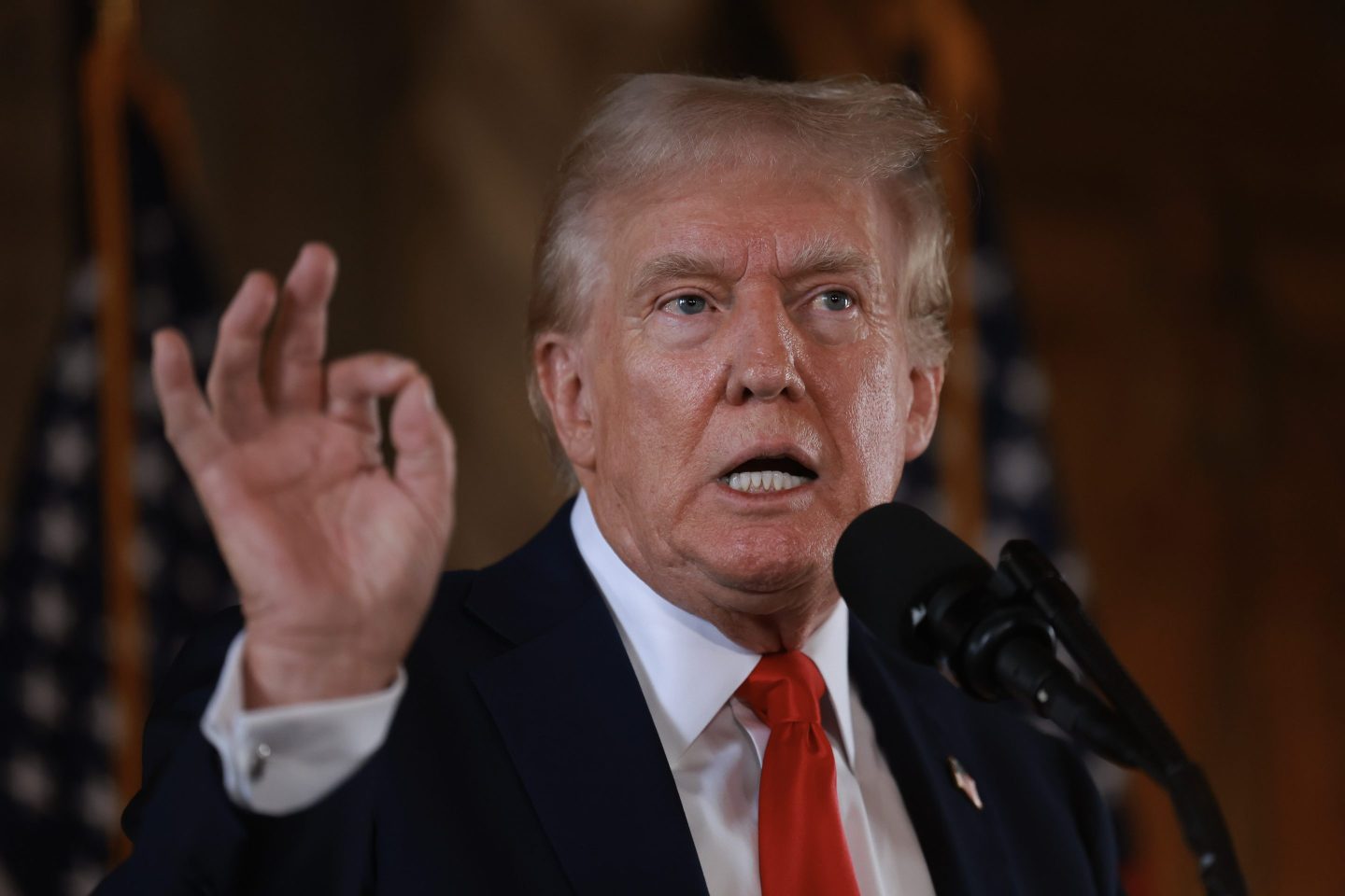 Former President Donald Trump making a hand gesture during a press conference