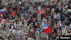 People carry pictures of World War II soldiers as they take part in the Immortal Regiment march during the Victory Day celebrations in central St. Petersburg on May 9.