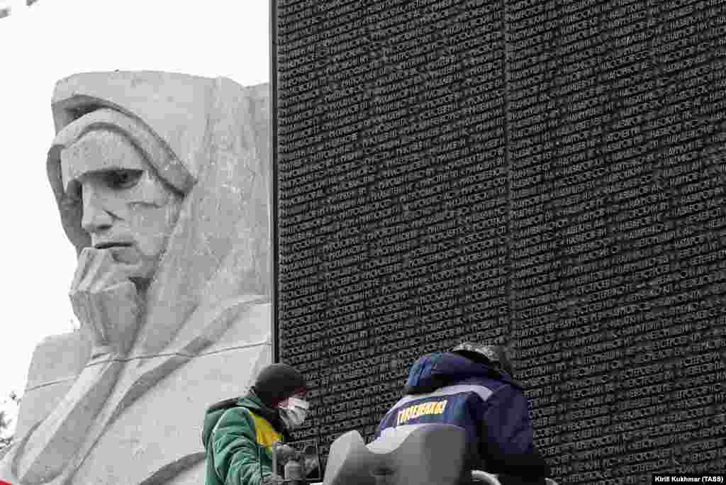 Workers clean the&nbsp;names of World War II soldiers at the Glory Monument in Novosibirsk on April 13, 2020. &nbsp;