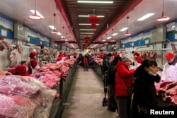 北京新发地农产品批发市场的肉类摊主在卖猪肉。（2024年2月2日）