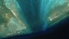 卫星图像显示在南中国海有主权争议的斯卡伯勒浅滩（中国称黄岩岛）潟湖入口处被安放了一道新的浮动屏障。（2024年2月24日）