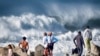 2023年12月28日，在加利福尼亚州曼哈顿海滩，海滩上的游客观看湍急的海浪冲击着曼哈顿海滩的海岸。（美联社照片）