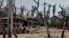 (FILE) A woman cooking next to destroyed houses and burned trees following fighting between Myanmar's military and the Arakan Army (AA) ethnic minority armed group in Rakhine State, May 21, 2024 