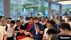 深圳一家华为商店的店员在向人们展示Mate 60系列手机。（2023年8月30日）
