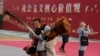 资料照：北京一名街头小贩走过“社会主义核心价值观”的宣传牌。（2024年1月20日）