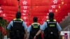 香港警察在香港主权移交中国27年纪念日走过挂满中国国旗和香港旗帜的街道。（2024年7月1日）