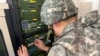 一名韩国士兵在在韩国坡州分隔朝韩两国的非军事区附近的军事演习中使用扬声器进行宣传广播。(2024年6月9日)