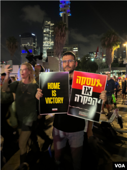 7月24日以色利首都特拉维夫的人质广场上，抗议者举着标语：“回家才是胜利” (美国之音/斯特芬妮·傅莱德)