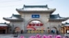 FILE - Tourists walk past a gateway with the name 'Beishan' seen at the Beishan Park in northeastern China's Jilin province, Jan. 23, 2020. Four instructors from Iowa's Cornell College teaching at Beihua University were attacked, reportedly with a knife.