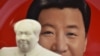 资料照：北京天安门附近一个纪念品商店里毛泽东的塑像摆在习近平纪念画盘的前面。（2018年2月27日）