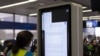 2024年7月19日，一名技术人员在芝加哥奥黑尔国际机场联合航空公司登机口附近的信息显示屏上工作。此前错误的 CrowdStrike 更新导致运行微软Windows 的计算机出现重大互联网中断。(美联社照片)