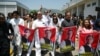 资料照片：巴基斯坦正义运动党 (PTI) 议员在伊斯兰堡议会大厦外举行抗议活动时举着印有被监禁的前总理伊姆兰·汗照片的标语。(2024年7月18日)
