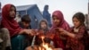 资料照片：从巴基斯坦返回的阿富汗儿童在边境避难所附近烤火取暖。(2023年11月4日）