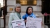 资料照片：人权活动人士海伦娜·肯尼迪（Helena Kennedy）（左）和拉希玛·马赫穆特 （Rahima Mahmut） 举着标语牌在伦敦英国外交部外面抗议,要求英国外相会晤维吾尔活动人士和幸存则。(2023年2月13日，)