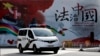资料照：一辆警车驶过北京街头一堵宣传中国法治的宣传墙。（2016年12月28日）