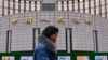 资料照片：一名女子走过位于北京的中国人民银行。(2024年2月20日)