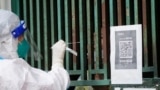 上海一名医务人员从一个固定新冠核酸采样点里给市民进行检测。（2022年5月5日）