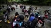 (FILE) Migrants cross a river during their journey through the Darien Gap from Colombia into Panama, hoping to reach the U.S., Oct. 15, 2022.