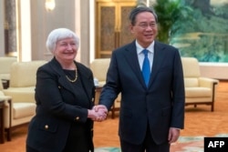 资料照：中国国务院总理李强（右）在北京人民大会堂与美国财政部长耶伦（左）会晤时握手。（2023年7月7日）