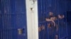 在曼谷市中心的警察移民拘留中心，被拘留者站在牢房栅栏后面。人权组织于2023年4月27日敦促泰国改善其移民拘留设施的条件，因为在两个月内又有一名来自中国的维吾尔族寻求庇护者在拘留期间死亡。（资料照片：2019年1月21日）