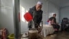 中国甘肃省地震灾区梅坡村的居民在移动房屋内烧水。（2023年12月21日）
