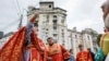 (FILE) A priest sprays holy water on believers during an Easter service in front of a recently damaged residential building by a Russian missile strike in Kyiv, Ukraine, May 5, 2024.