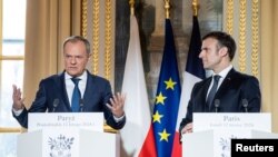 波兰总理图斯克（左）与法国总统马克龙在巴黎爱丽舍宫举行的记者会上。（2024年2月12日）