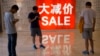 资料照片: 2016年7月10日中国北京购物区促销广告和购物者