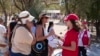 资料照片：希腊雅典的红十字会志愿者向游客发放饮用水。(2024年7月17日)