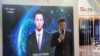 在中国乌镇国际互联网大会上，新华社新闻主播邱浩站在以他为原型的人工智能技术合成的新闻主播播放新闻的屏幕前(2018年11月7日)