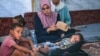 (FILE) Palestinian boy who contracted polio a month ago sleeps surrounded by family members in their displacement tent in Deir al-Balah in the central Gaza Strip on August 27, 2024.