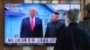 资料照片: 2019年12月31日人们在韩国首尔火车站观看朝鲜领导人金正恩和美国总统特朗普(左)会面画面