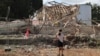 (FILE) A girl looks at a destroyed building in the aftermath of an Iranian missile attack on Israel, on October 2, 2024.