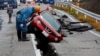 2024年1月3日，日本赤水附近，一名工人查看一辆在地震后被困在道路裂缝中的汽车。（路透社照片）