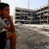 طفل يجلس أمام إحدى مدارس الأونروا في غزة التي تحولت إلى ملجأ للنازحين.
