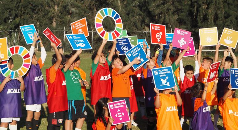 أطفال من مدينة زوتشيميلكو يحملون لافتات لأهداف التنمية المستدامة بعد تدريب لكرة القدم في نادي أكالي في زوتشيميلكو في مكسيكو سيتي.