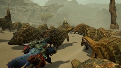 Monster Hunter Wilds – snímka obrazovky zobrazujúca lovca, ktorý prechádza skupinou tvorov v púšti.