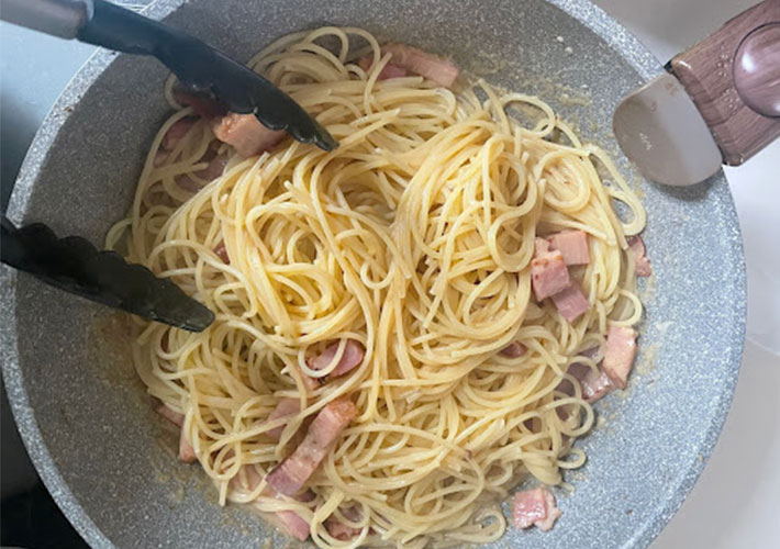 ゆでたパスタを加えて混ぜている写真