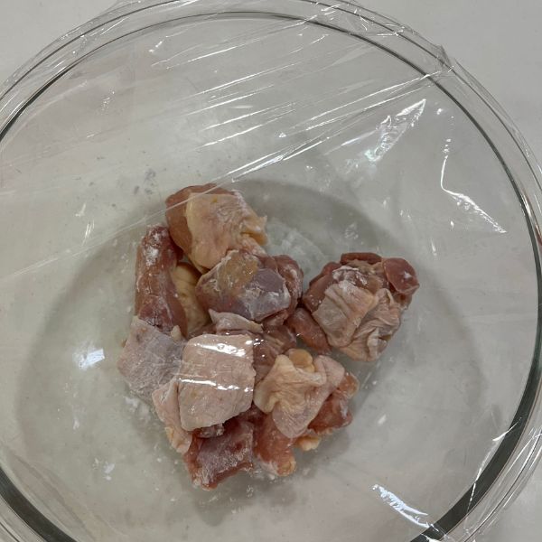 片栗粉をなじませた鶏もも肉を入れた耐熱容器にラップをした様子
