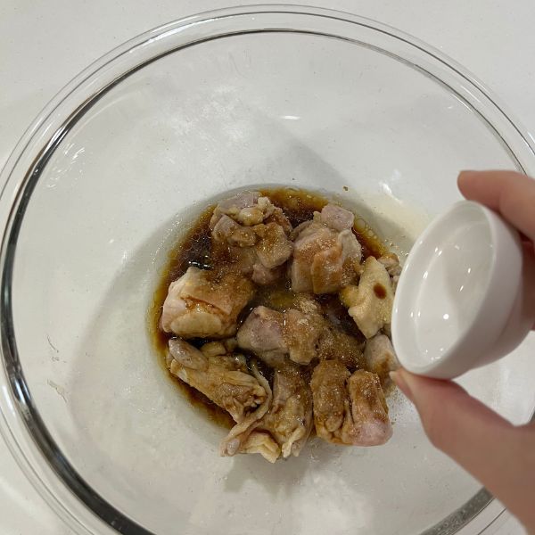 加熱した鶏もも肉に調味料をかける様子