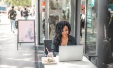 young woman on laptop while sitting outside